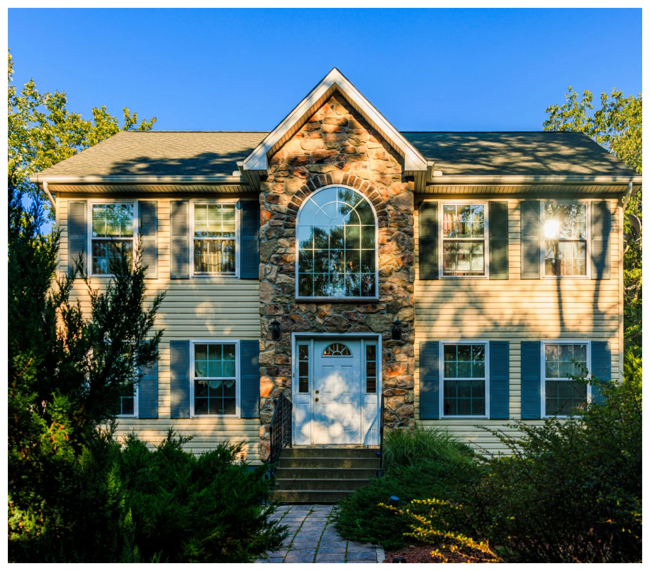 Two-story house with stone facade.