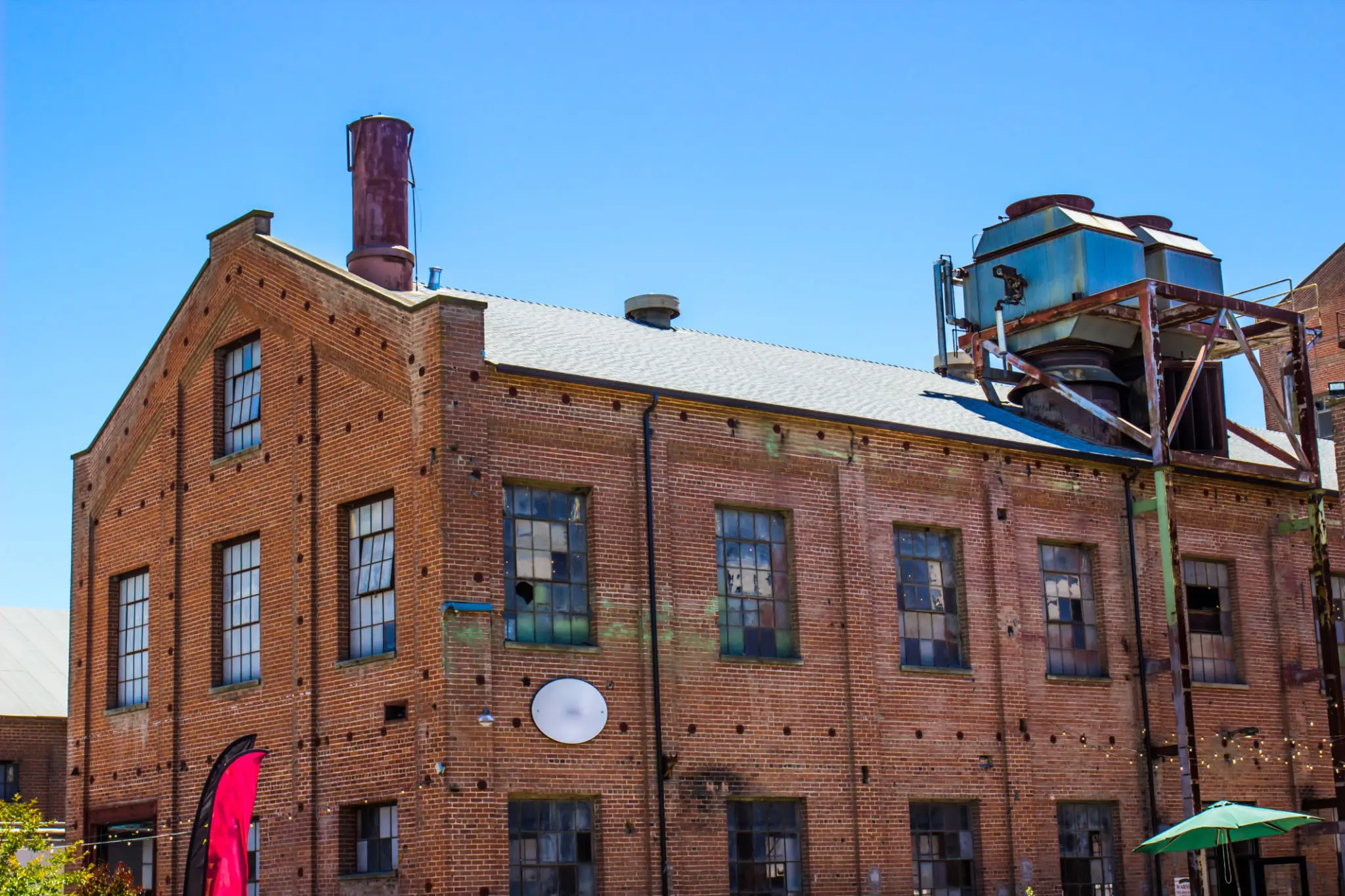 Old brick industrial building with rooftop equipment.